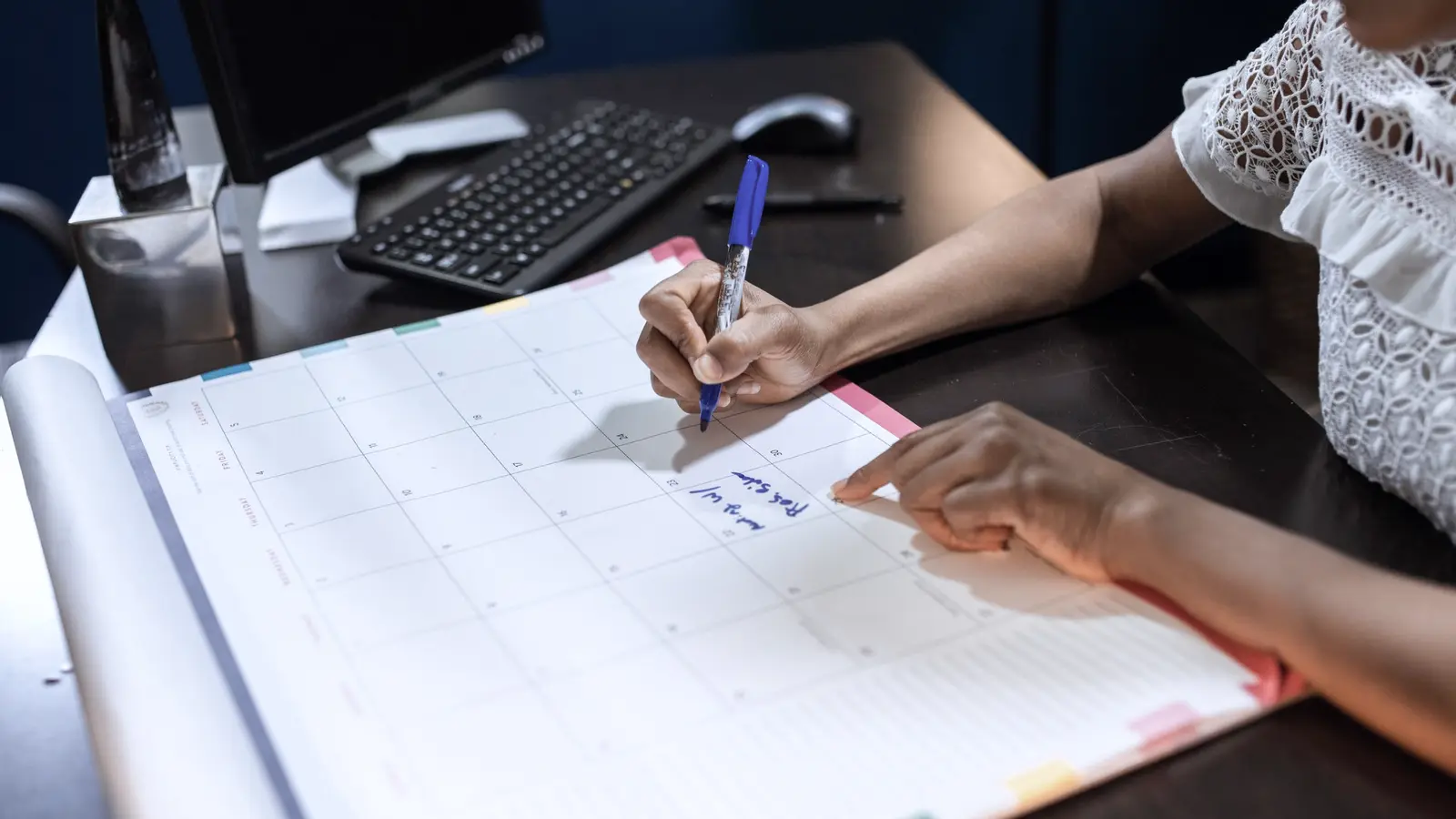 Medewerker plant data en schrijft aantekeningen op een grote bureaukalender