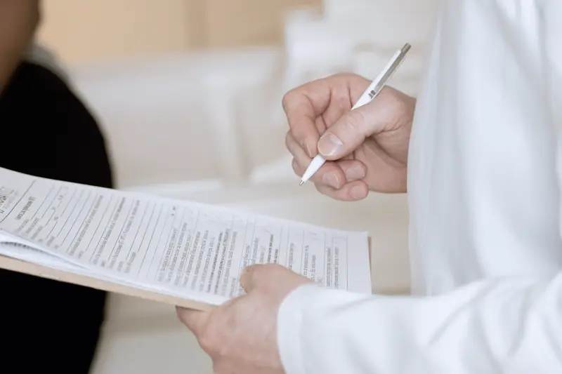 Zorgprofessional in witte jas loopt een checklist op een klembord na