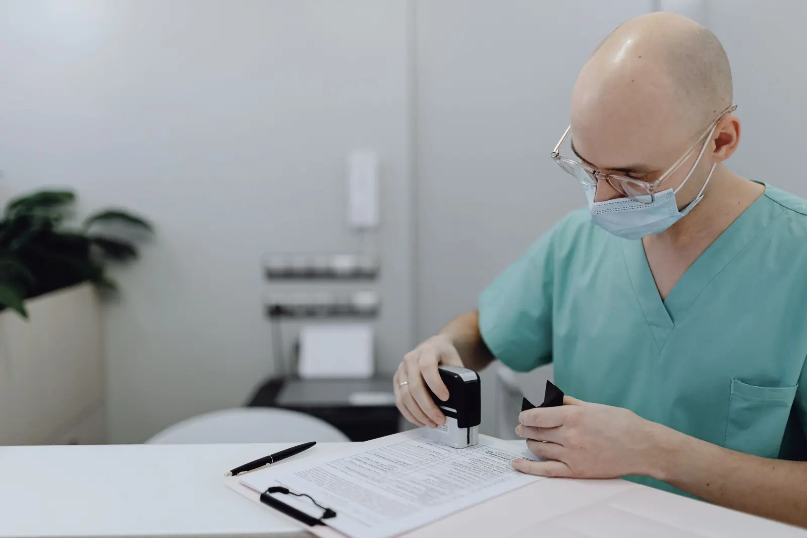 Zorgprofessional zet een stempel op een document aan een kliniekbureau